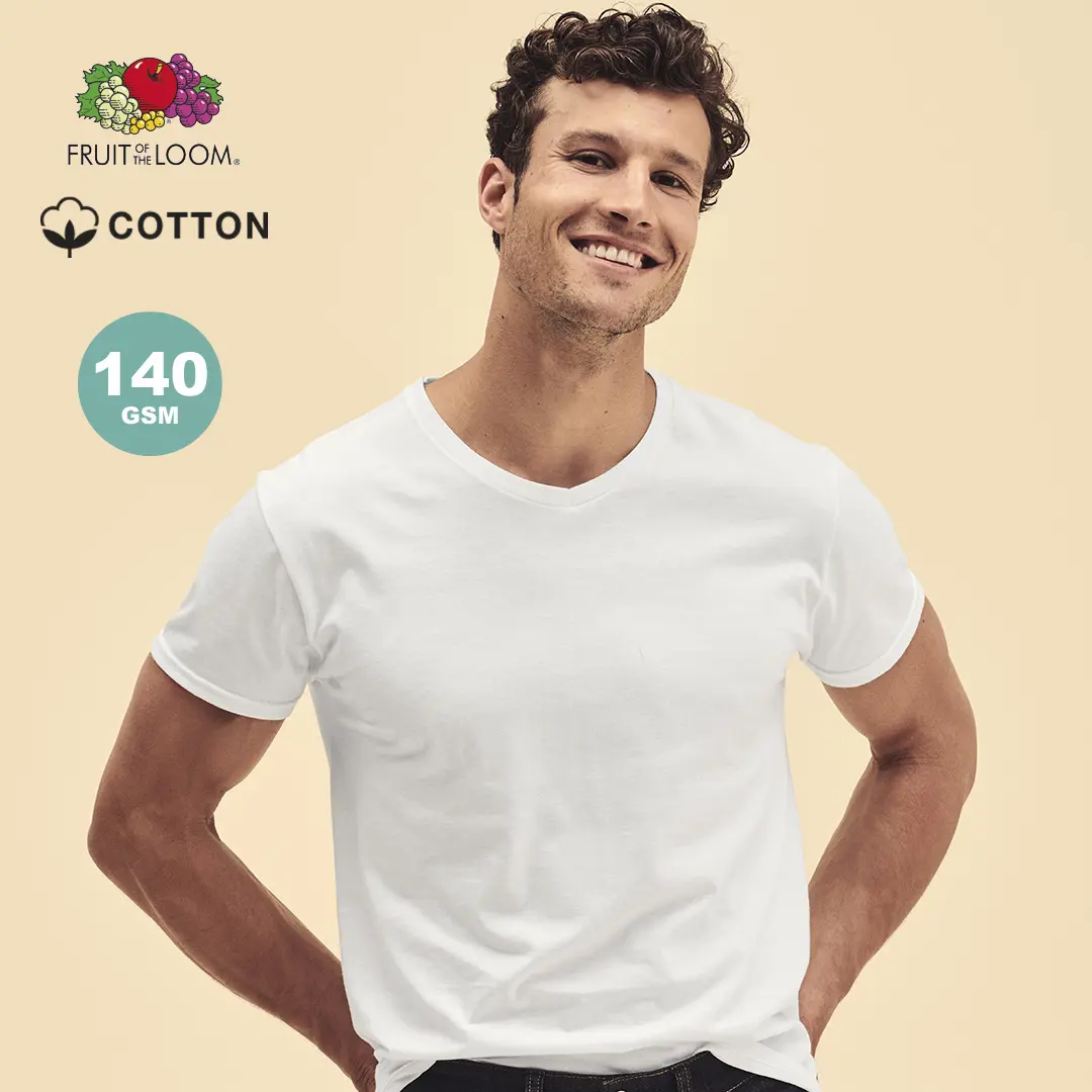 Hombre sonriente con camiseta blanca de algodón Fruit of the Loom 140 GSM sobre fondo beige.